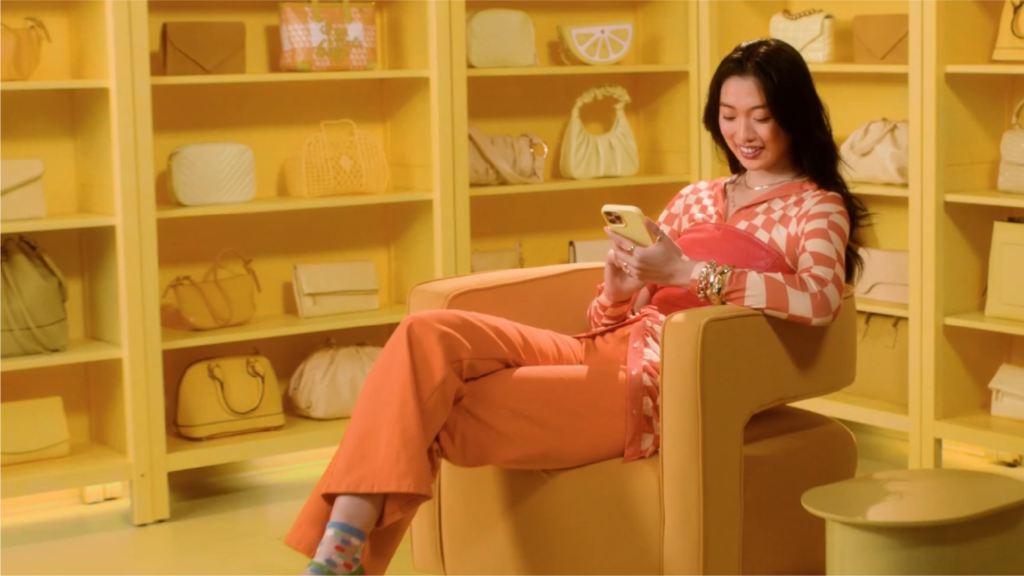 nate woman scrolling through social media in a yellow room