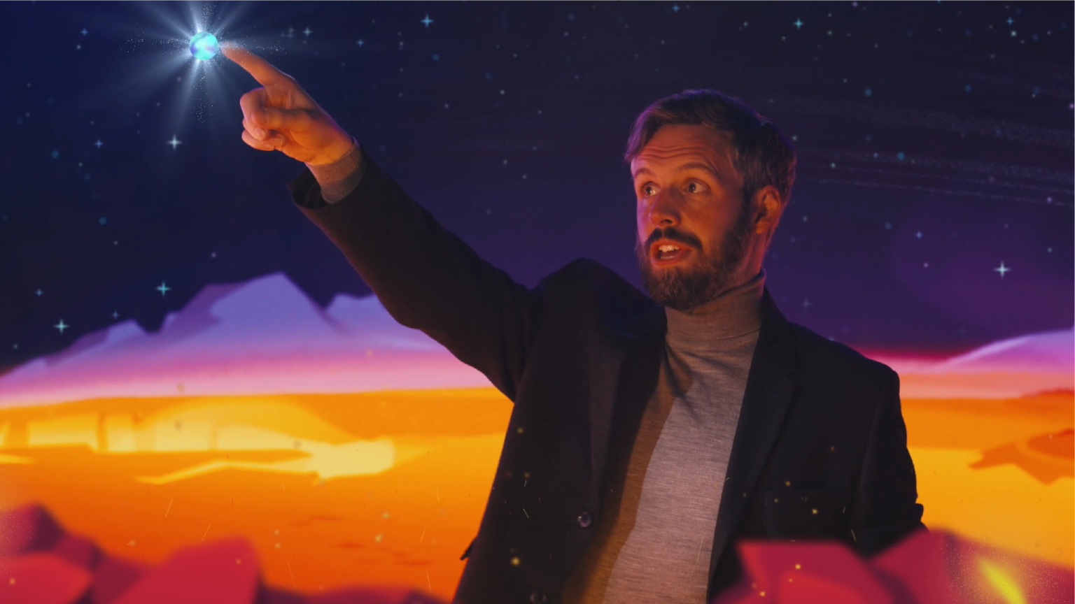 man with LED backdrop pointing at a planet