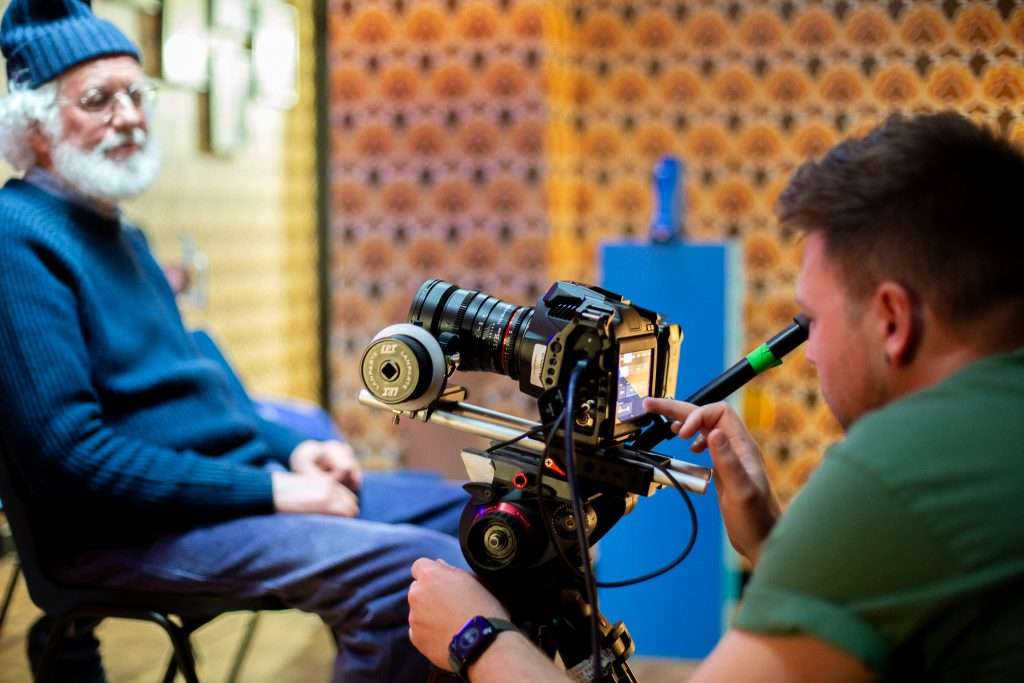 person on a video production set filming an old man